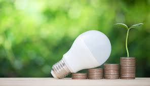 bombilla LED sobre monedas representando ahorro energético en viviendas y negocios en Cádiz