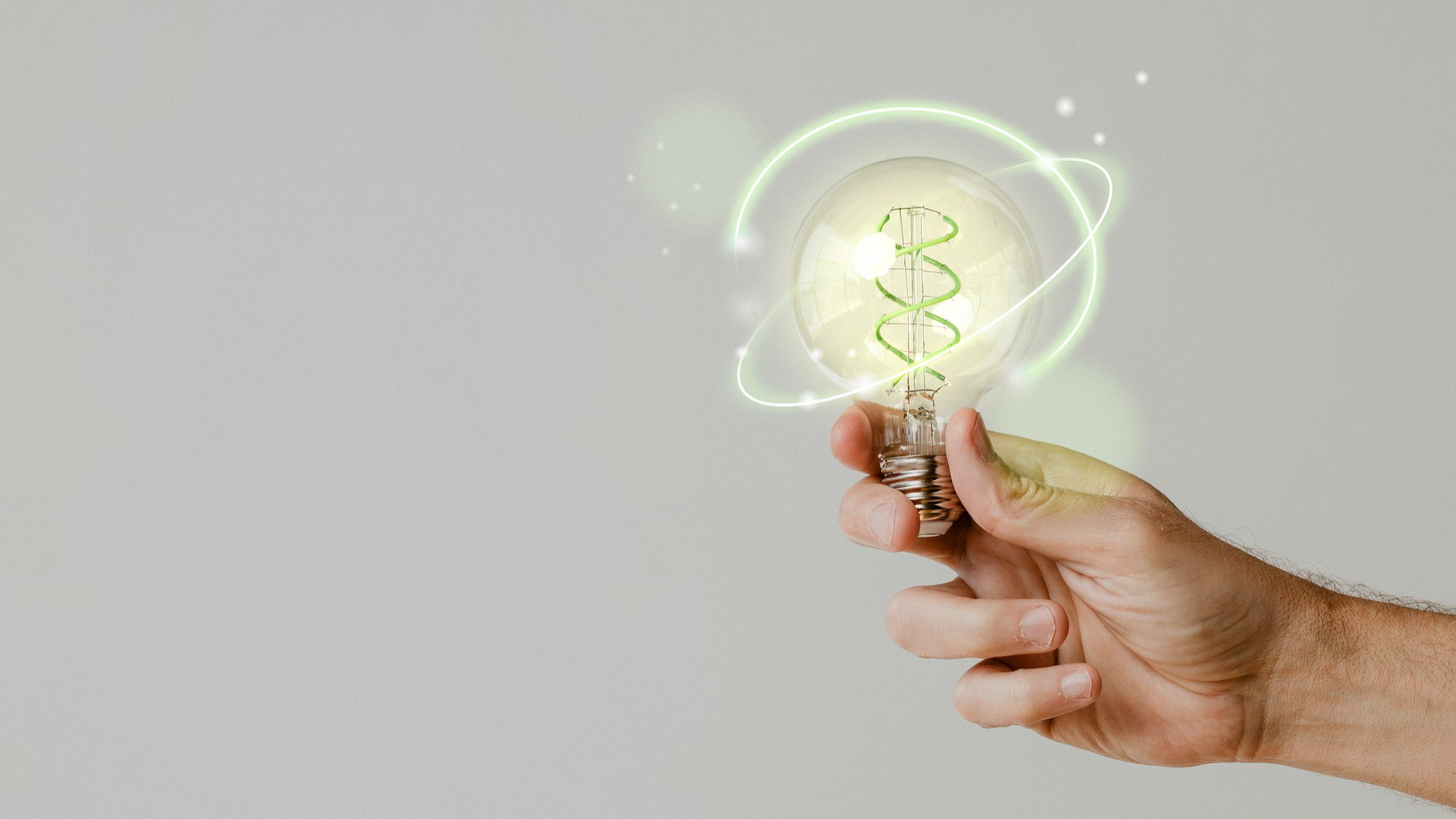 mano sujetando bombilla con icono energético representando innovación en eficiencia energética en Cádiz